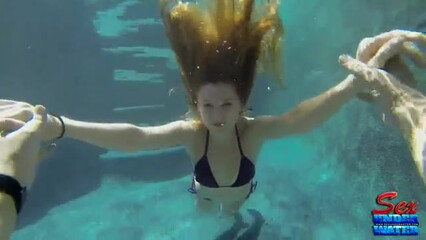 Голая нимфа развлекается под водой в бассейне